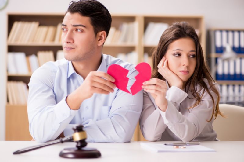Pareja con un corazón roto y un martillo judicial en el contexto de un divorcio.