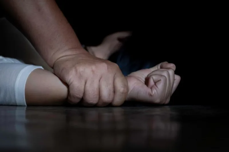 Mano sujetando con fuerza el brazo de una persona en un contexto de agresión física, representando delitos sexuales.