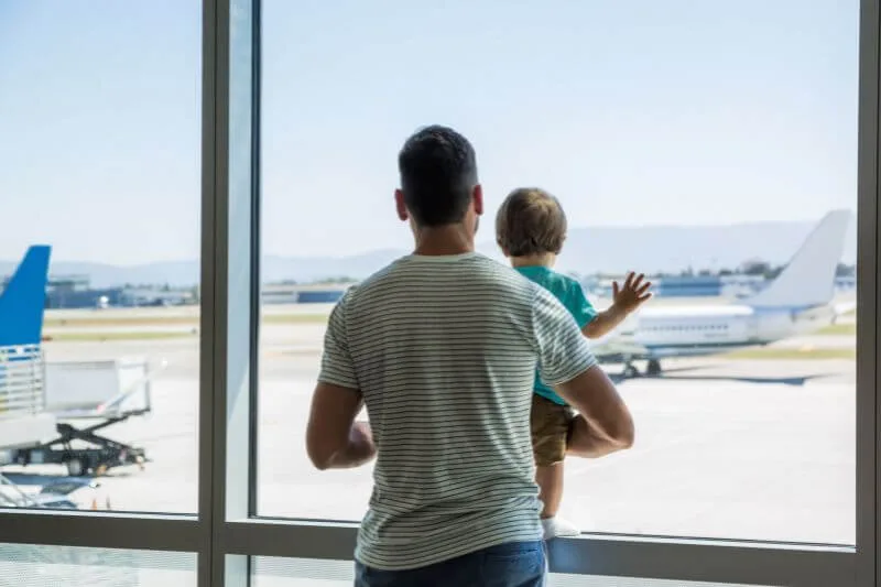 Padre con su hijo en el aeropuerto antes de viajar con menores al extranjero